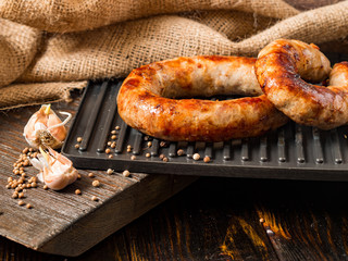 Spicy homemade sausages pork and beef sausages, on a wooden background, with sauce and spices. Template in rustic style.