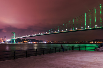 Istanbul Bosphorus Bridge (15th July Martyrs Bridge) with green light. Istanbul, Turkey..
