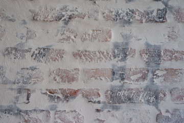 Verputztes Mauerwerk aus Ziegelsteinen mit grauen Fugen