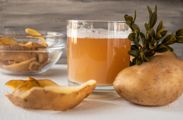 Juice with potatoes in a glass. Peeled potatoes.