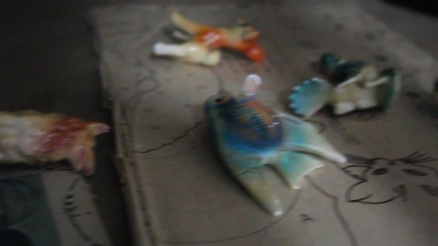 Scary looking porcelain dolls scattered across scary looking clown pictured paper