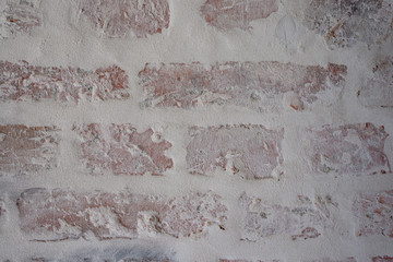 Verputztes Mauerwerk aus Ziegelsteinen mit grauen Fugen