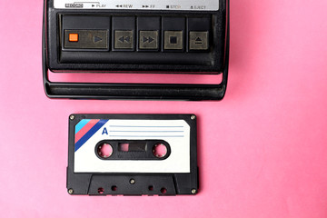 Old retro vintage 80s style portable cassette recorder radio and audio  tape cassette on a pink...