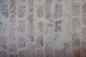 Verputztes Mauerwerk aus Ziegelsteinen mit grauen Fugen