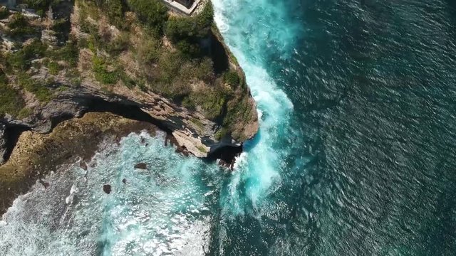 Drone aerial shot over the cliff of Uluwatu temple
