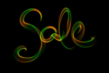 Fototapeta premium SALE word made of fire or smoke in green and red colors in hot sparkly design on black background
