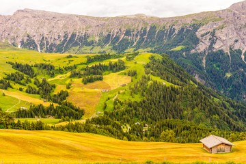 Obraz premium Alpe di Siusi, Seiser Alm with Sassolungo Langkofel Dolomite, a large green field with a mountain in the background
