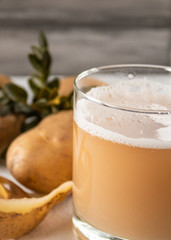 Juice with potatoes in a glass. Peeled potatoes.