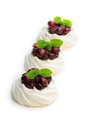 Mini Pavlova meringue nests with cranberry and mint leaves isolated on white
