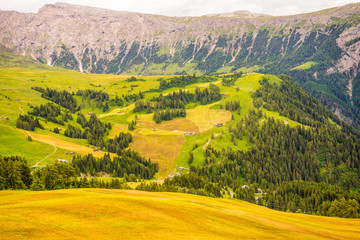 Obraz premium Alpe di Siusi, Seiser Alm with Sassolungo Langkofel Dolomite, a large green field with a mountain in the background
