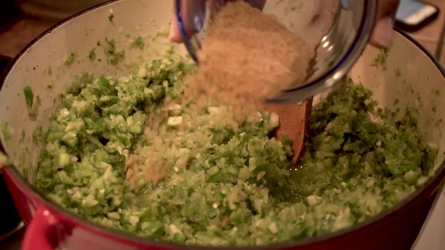 SLOW MOTION pouring cumin on top of green vegetable mixture, Close Up