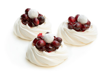 Mini Pavlova meringue nests with fresh and sugared cranberry isolated on white