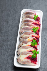 Herring slices stuffed with beetroot and potato arranged in a serving dish