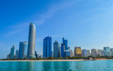 Obraz na płótnie Canvas Abu Dhabi city skyline along Corniche beach taken from a boat
