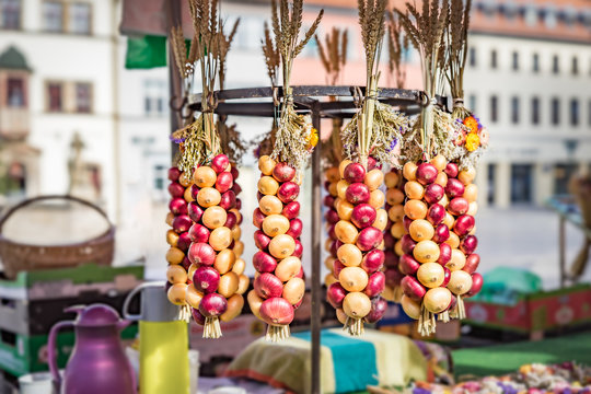 aufgehängte Zwiebel Zöpfe auf einem Wochenmarkt