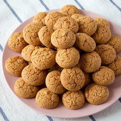 Almond cookies on pink plate, low angle view.