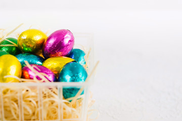 Wrapped chocolate candies with egg's form in plastic basket