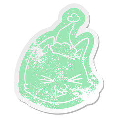 spitting cartoon distressed sticker of a cat face wearing santa hat