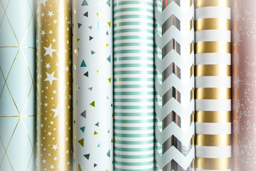 Rolls of festive wrapping paper as background. Top view