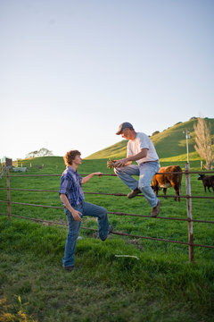 Man and his teenage son working on a farm