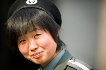Portrait of a young adult security woman standing outside.