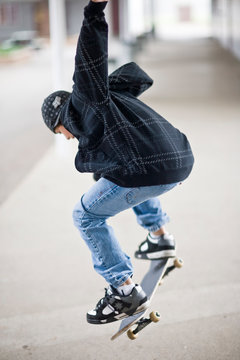 Teenage boy doing a trick on his skateboard.