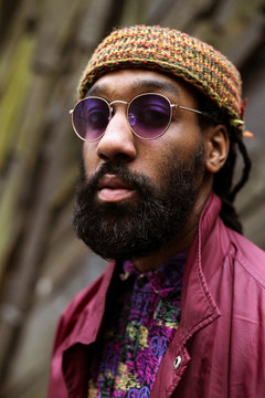 Close up of adult with beard and purple tinted sunglasses