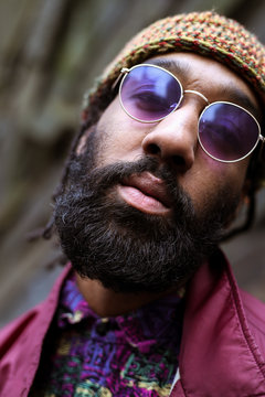 Close up of adult with beard and purple tinted sunglasses