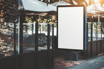 Vertical empty advertising poster mock-up at the entrance of the street part of a restaurant; blank...