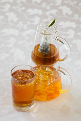 Afternoon tea service with iced tea maker and glass on white linen table cloth