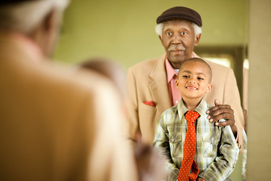 Senior man looking in the mirror with his grandson.