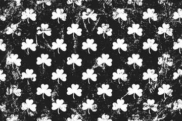 Grunge pattern with signs of shamrocks. Horizontal black and white backdrop.