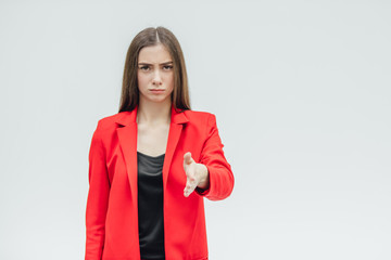Portrait of a beautiful young brunette. Stretches your hand in congratulations. Dressed in a red...