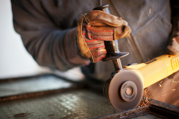 Hands of a metalworker fixing a tool.