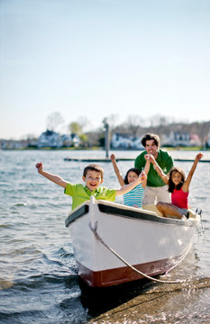 Family at beach with row boat.
