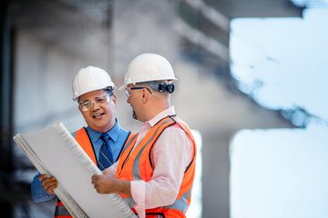 Workers at construction site discuss progress.