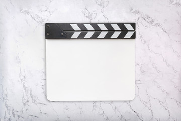White clapboard on white marble background. Clapper board template. Flat lay. Top view