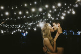 Young couple kissing under lights
