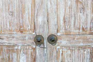 Wooden teak door with a metal handles.