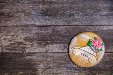 Round handpainted gingerbread on wooden background. Beautiful car with flowers. Flat lay. Copy space. Sweet dessert as a gift for women's day on 8 March