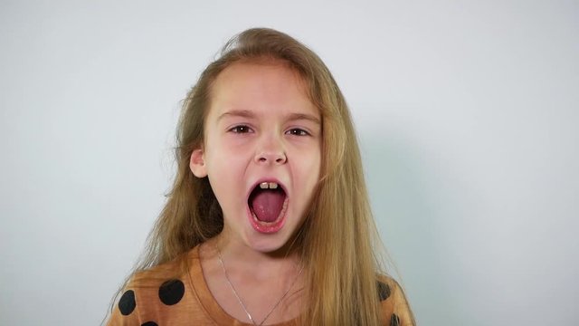 Young caucasian girl screaming into the camera. Slow motion