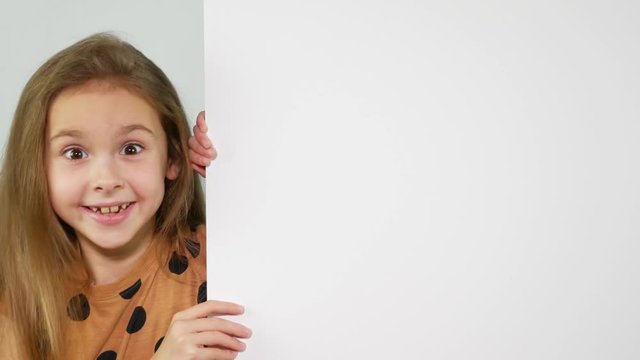 Portrait of young girl holding blank placard smiling at camera isolated on white background. Copy space.