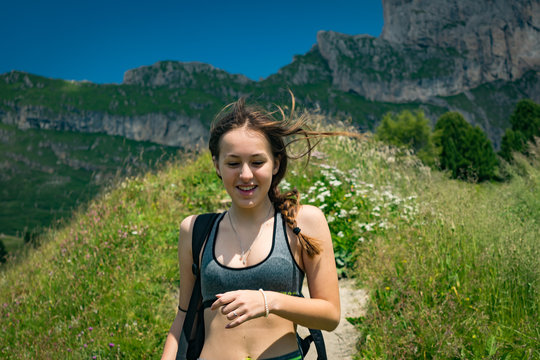 Happy young woman in closeup doing trecking on the mountain ridge of the Italian Alps