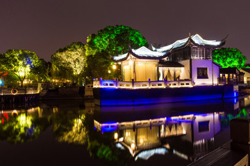 Beautiful reflected and illuminated boat  on the canal of Zhouzhuang by night, China