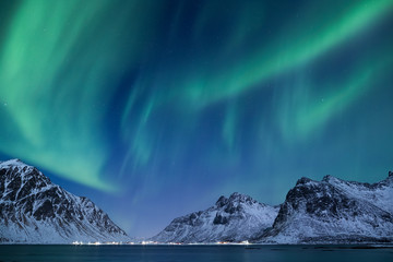 Beautiful northern lights over the snow covered winter landscape of the Lofoten islands