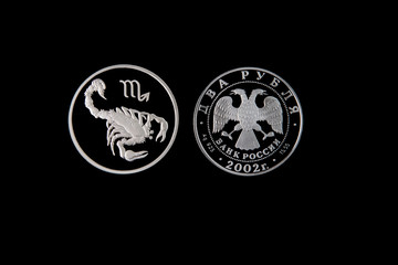 Silver coin of the Bank of Russia with the sign of the zodiac Scorpio on a black isolated background. The coin says: 