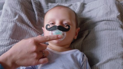 portrait cute baby with moustache pacifier sucking on dummy