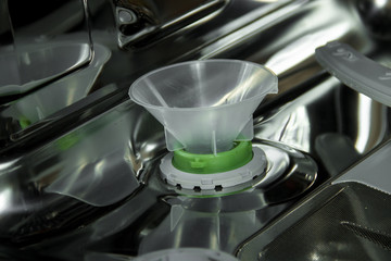 View of the interior of an empty opened dishwasher. Maintenance of home appliances.