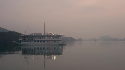 Tourist cruise boat moored in the limestone islands of Ha Long Bay the UNESCO World Heritage site in Cat Ba National Park, Vietnam