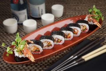 Sushi roll appetizer at Restaurant with sake cups and chop sticks